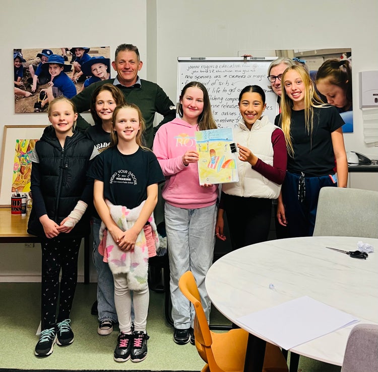 Mr Bond, Mrs Rogers and a group of female student not in uniform displaying the outcome of their project.